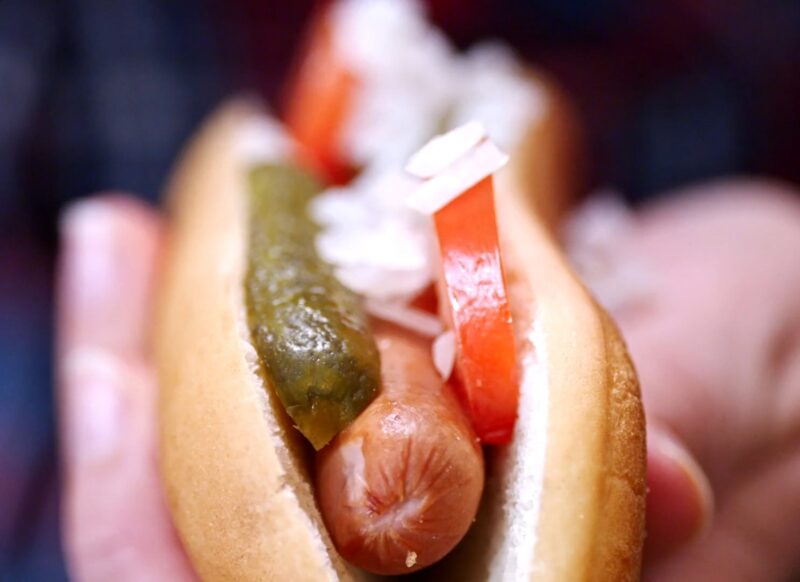 osoba drži hot dog u ruci